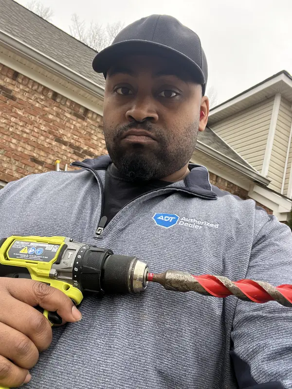 Safe Dwelling Security technician with a drill on an install