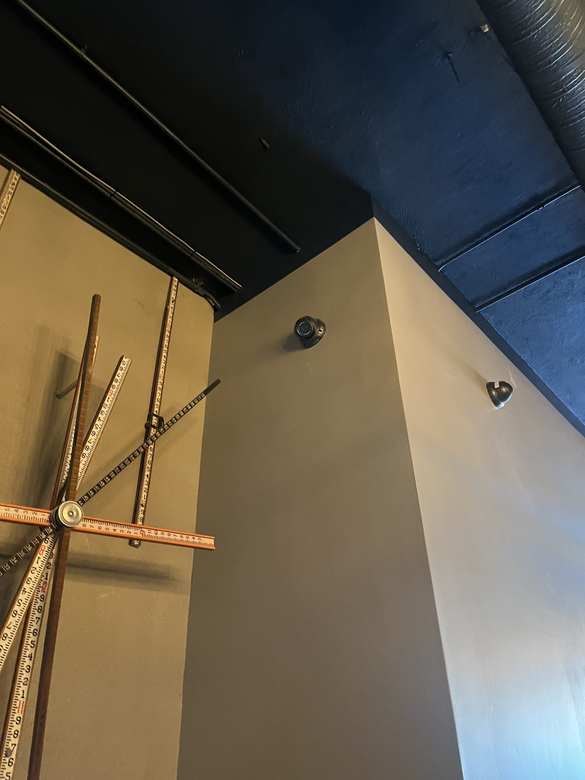 Two cameras covering the corner of a commercial interior